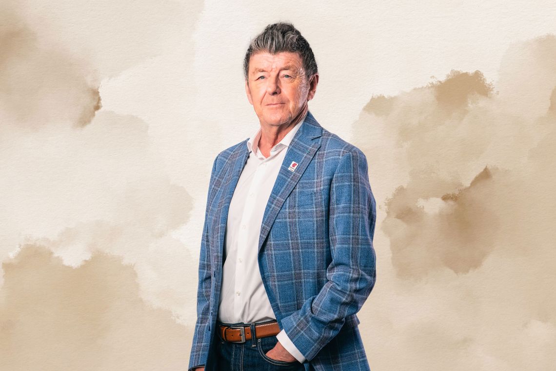 Vince Andrews standing in front of an abstract background.