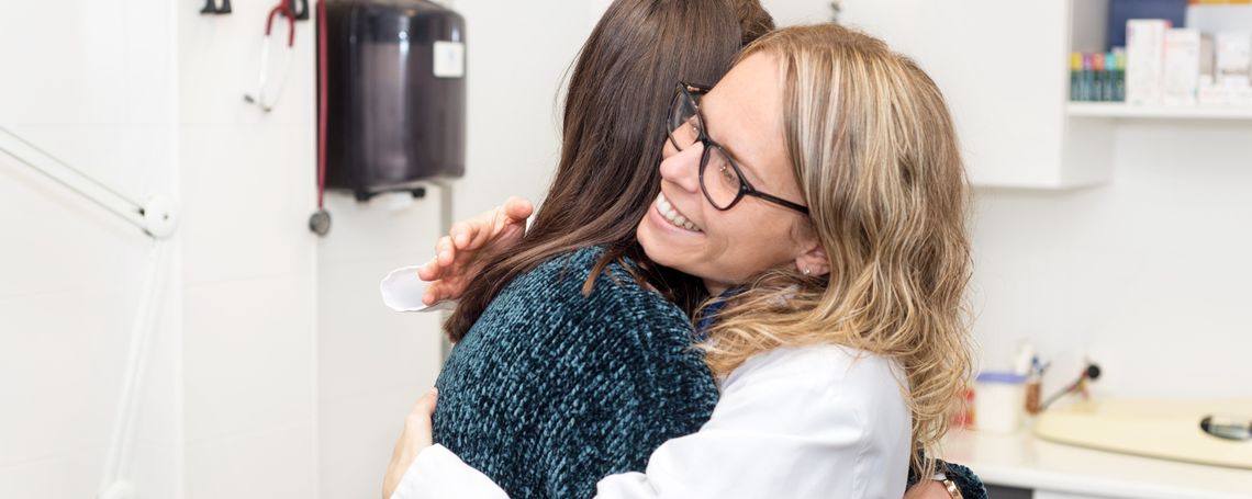 Two women hugging each other