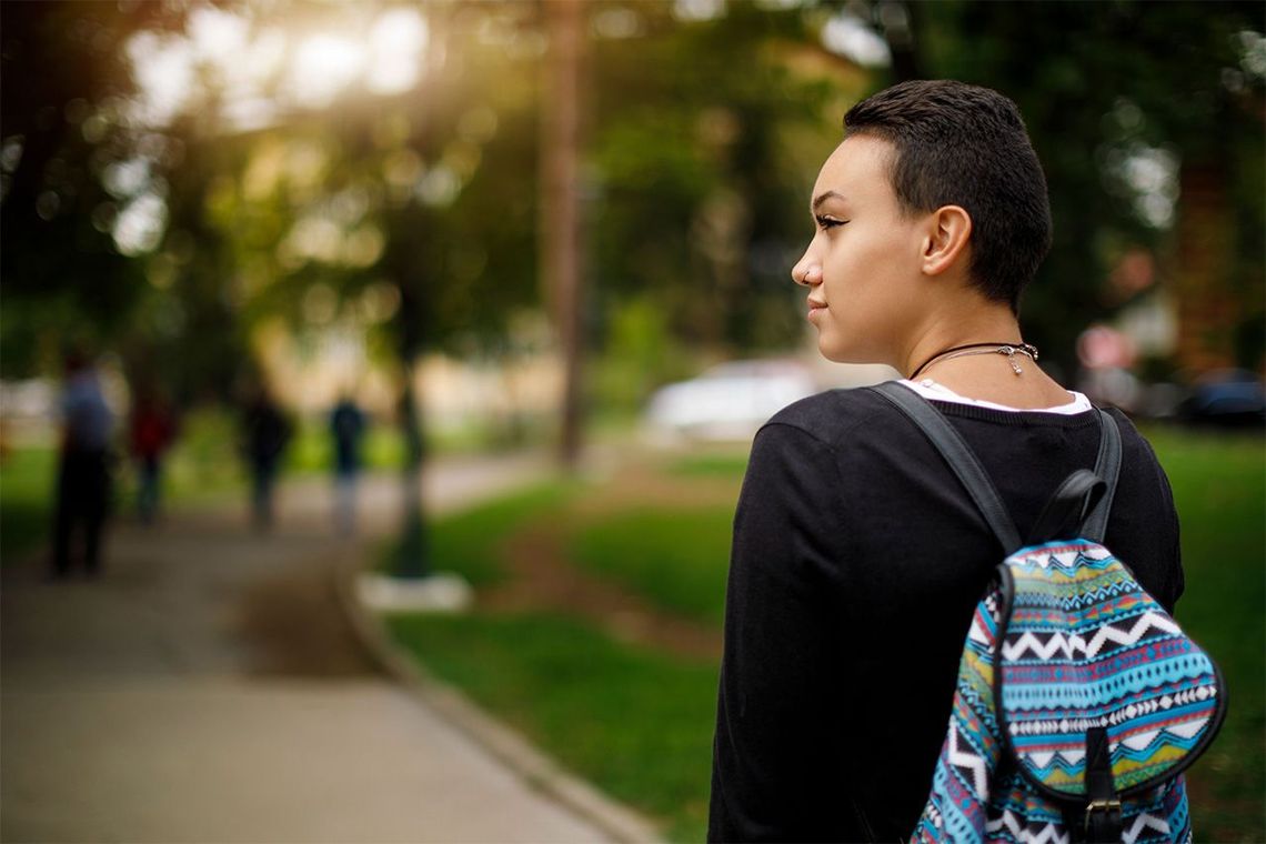 Back view of a young woman looking to her left.