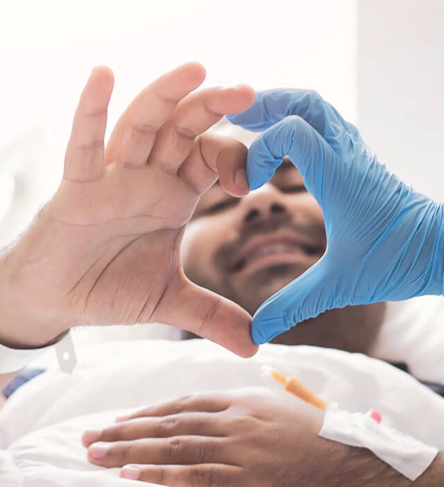 Une photo d'une main de patient et d'une main gantée faisant un cœur