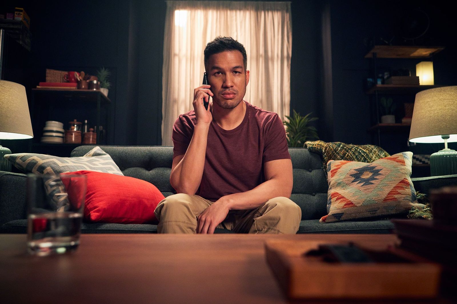 Man on an important phone call, sitting in his living room.