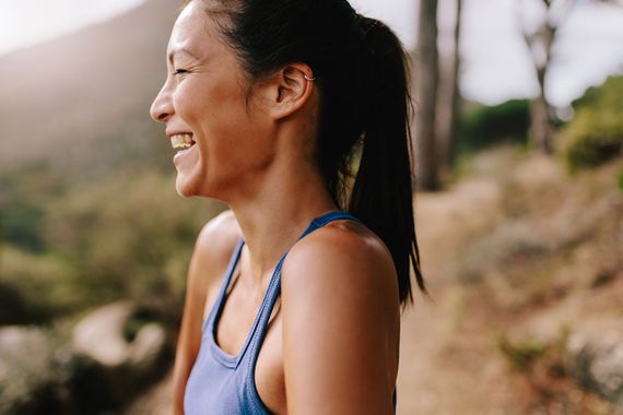 Woman laughing outdoors on a hike