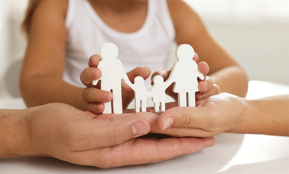 Hands holding a paper form of a family