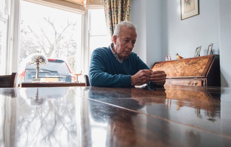 An elderly person sitting at a table