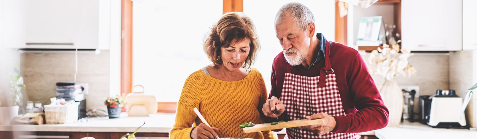 Un homme âgé et une femme cuisinant ensemble