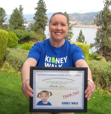 Annick holding a framed certificate