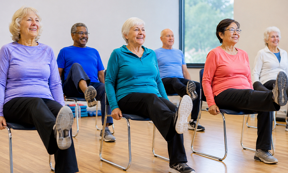 A group, sitting on chairs, doing exercices