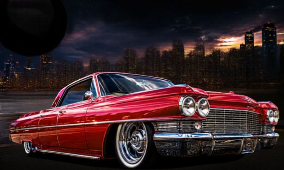 Une voiture rouge classique avec la ville en arrière-plan