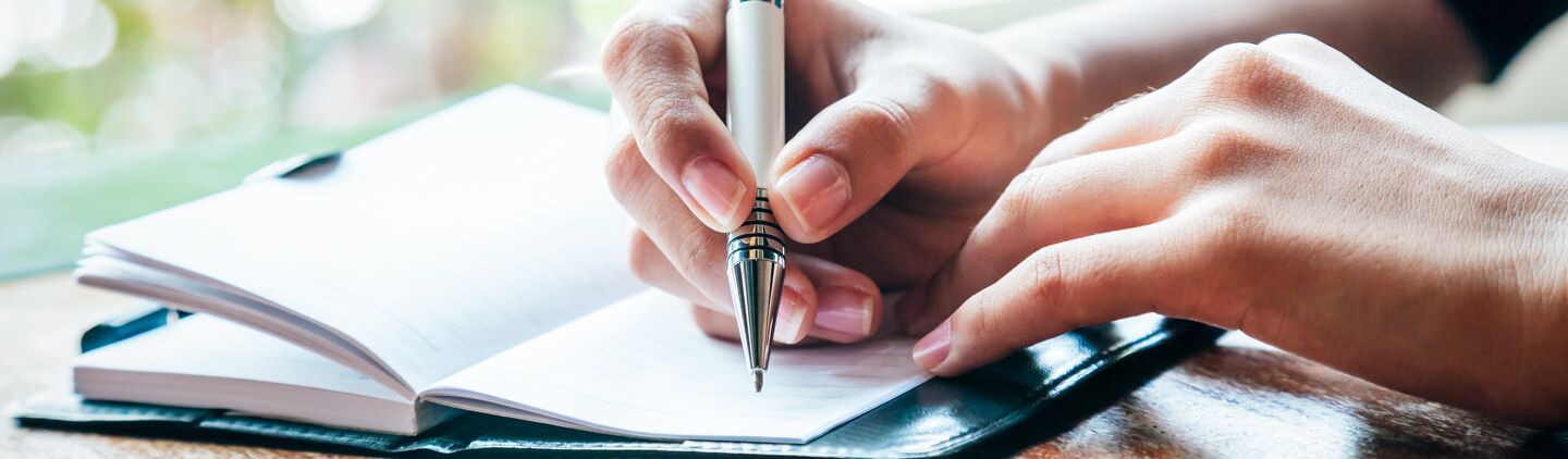 Hands writing in a notebook