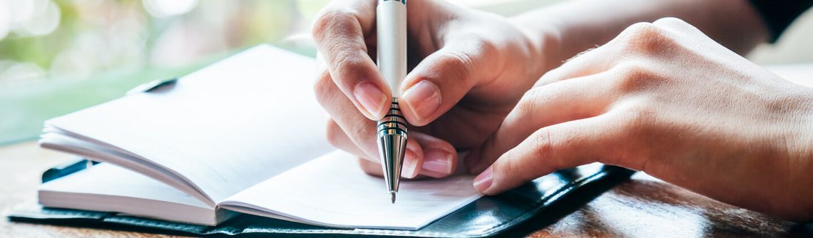 Hands writing in a notebook