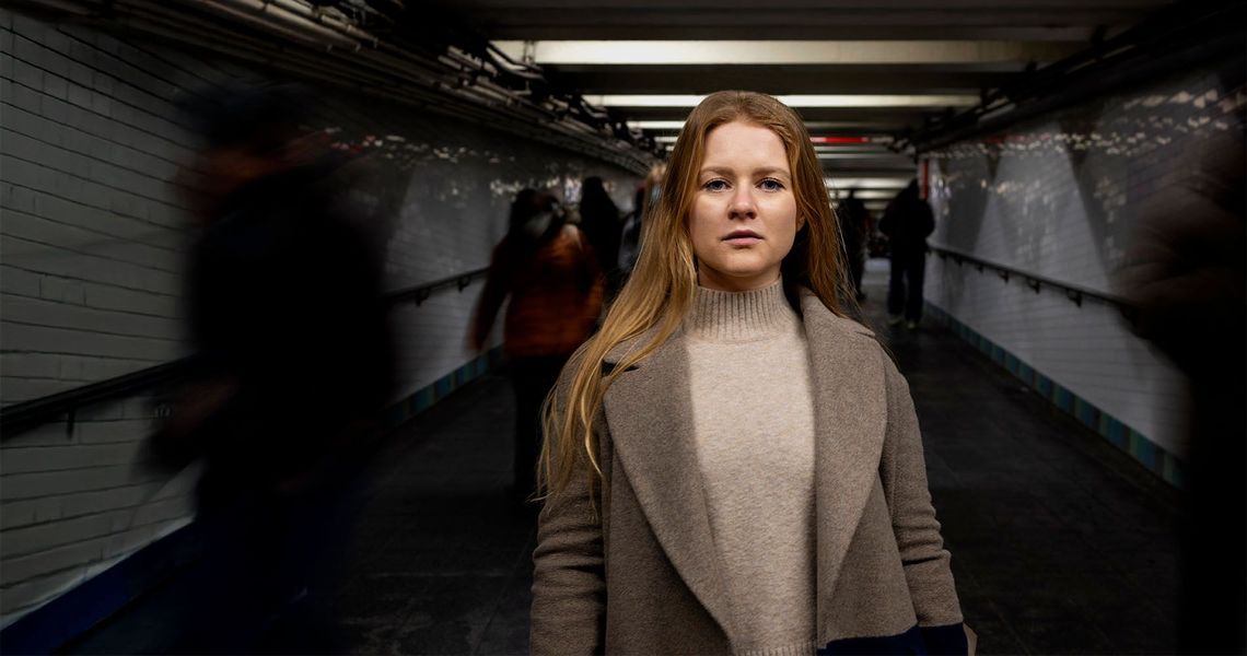 Femme à l'expression préoccupée dans un couloir sombre