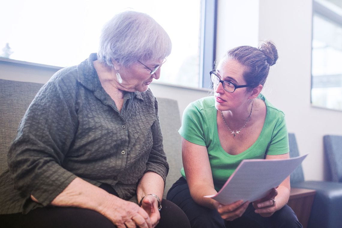 Deux personnes sont assises et examinent un document papier.